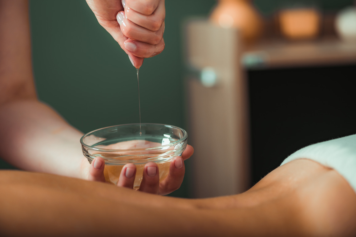 a nuru gel in a container about to be applied to a client